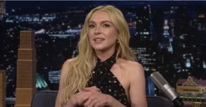 Lindsay Lohan before and after transformation, smiling in a black sequin halter dress during her interview on The Tonight Show Starring Jimmy Fallon